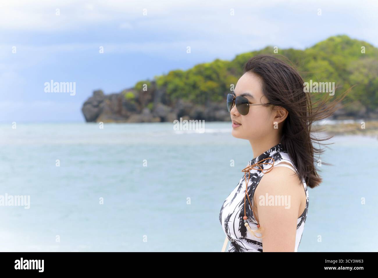 Belle femme portant touristiques sunglasse smiling regardant la nature paysage de la plage et de la mer en ciel d'été sur l'île de Tarutao Pa National Banque D'Images