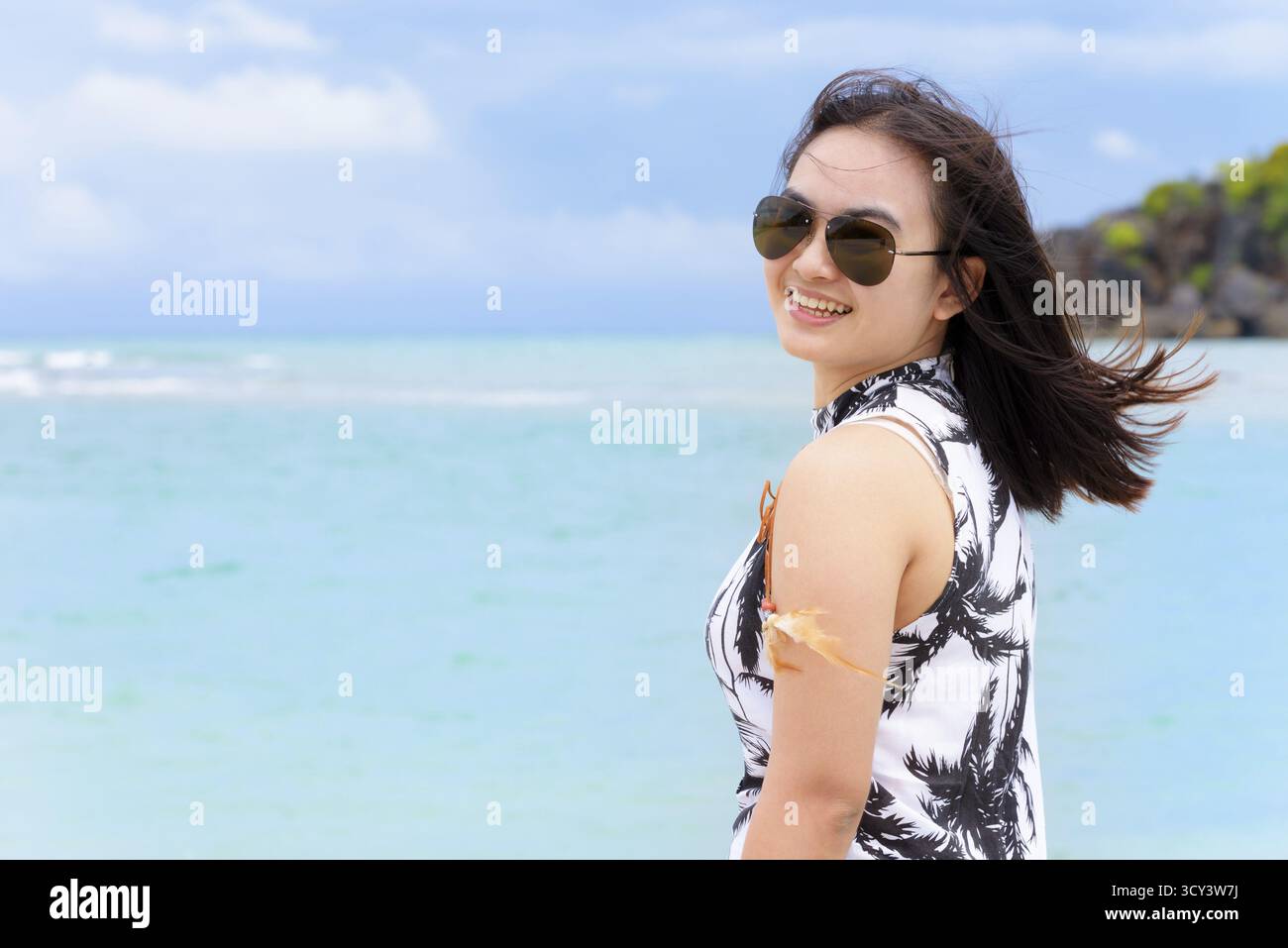 Belle femme port touristique sunglasse regardant la caméra et souriant de plaisir sur la plage et la mer en fond de ciel d'été à Koh Tarutao est Banque D'Images