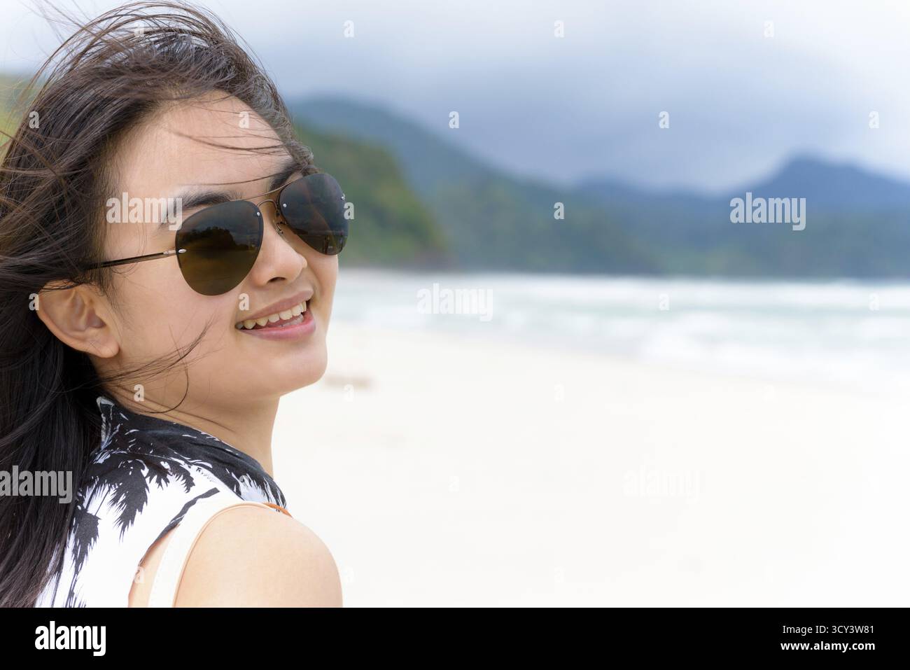 Gros plan face belle femme touriste portant sunglasse regardant la caméra et souriant avec Happy sur la plage et la mer en été à l'île de Tarutao Banque D'Images