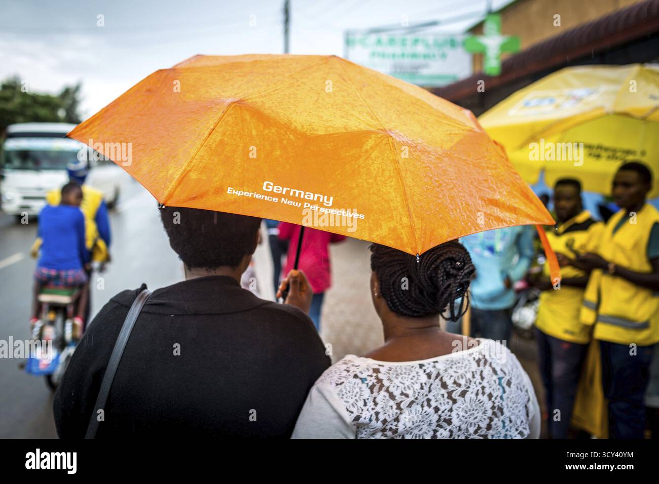 RWA RWANDA RUANDA Kigali Une femme porte un parapluie étiqueté 'Deutschland Experience New perspectives' Banque D'Images