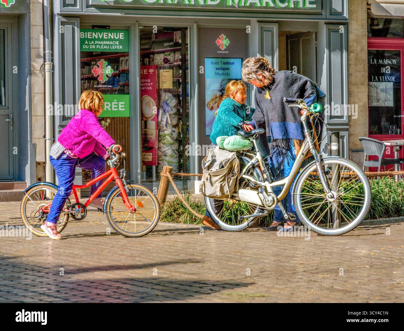 Mère préparant ses deux filles pour leur balade à vélo à travers le centre-ville - Tours, Indre-et-Loire (37), France. Banque D'Images