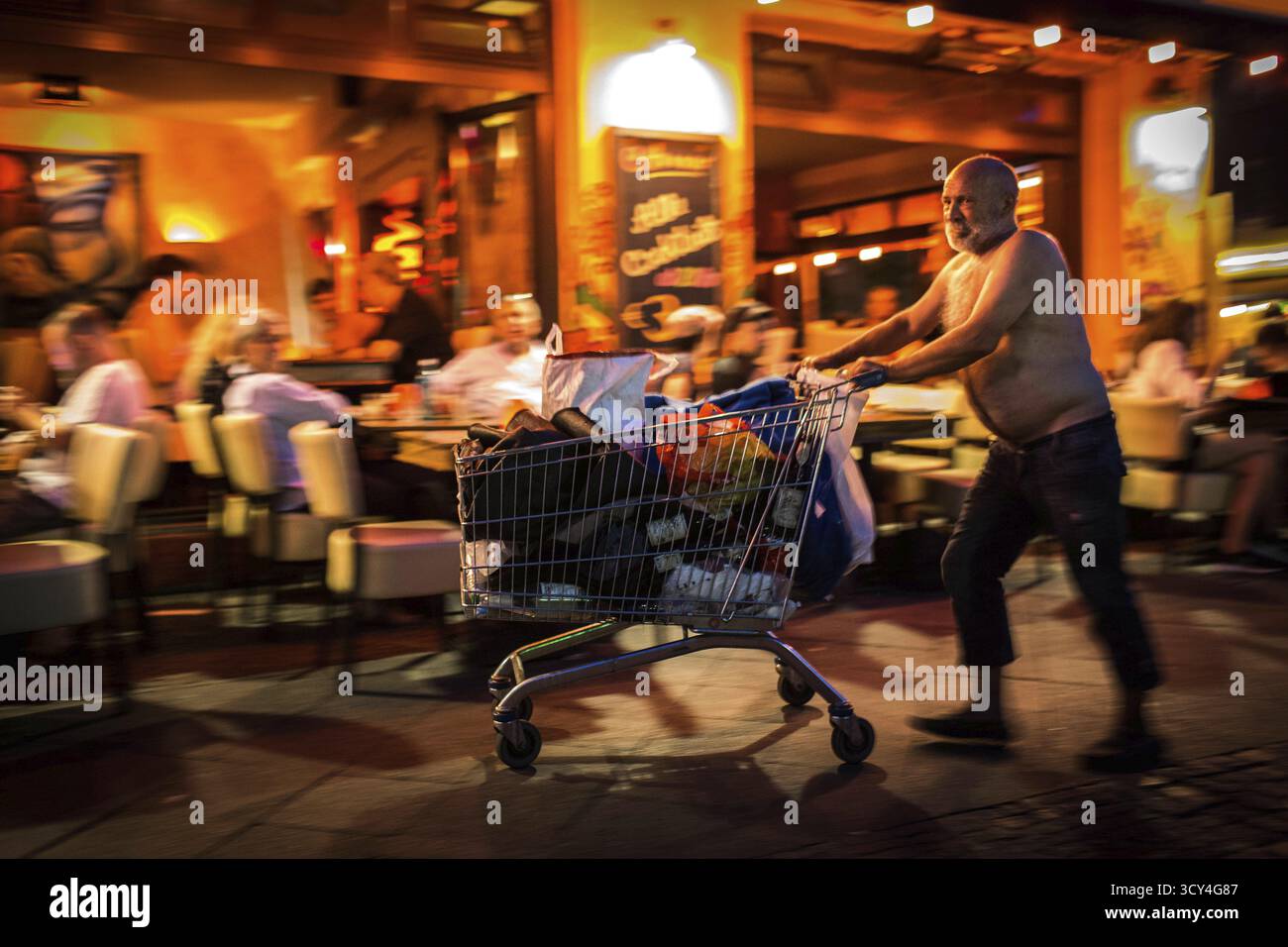DEU Allemagne Berlin scène de rue à Berlin-Kreuzberg. Le sans-abri pousse un panier avec ses affaires à travers Silesian Street dans le Banque D'Images