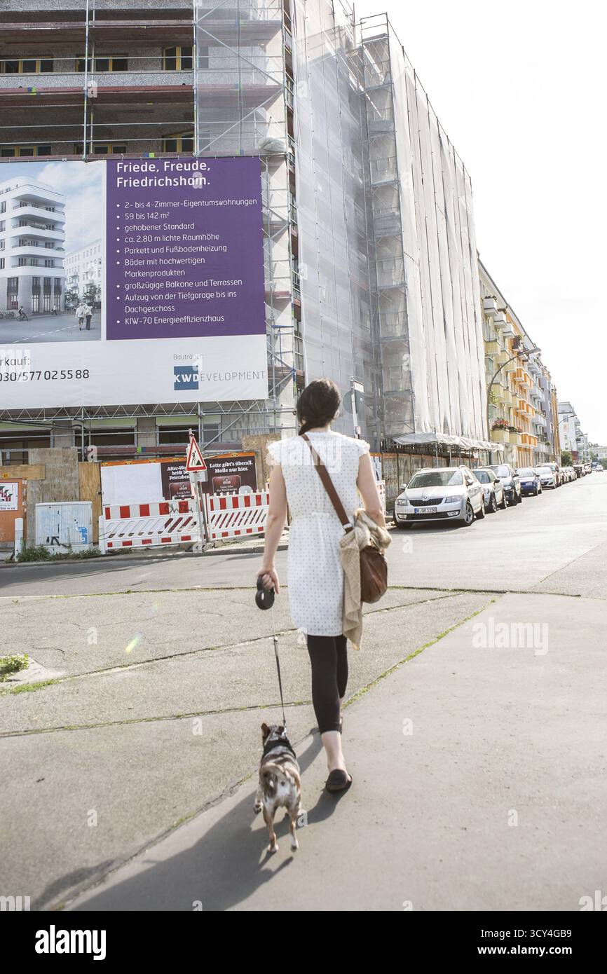 DEU Allemagne Berlin scène du quartier des collectionneurs de Berlin-Friedrichshain. Femme avec chien arrive une publicité pour le logement en FR Banque D'Images