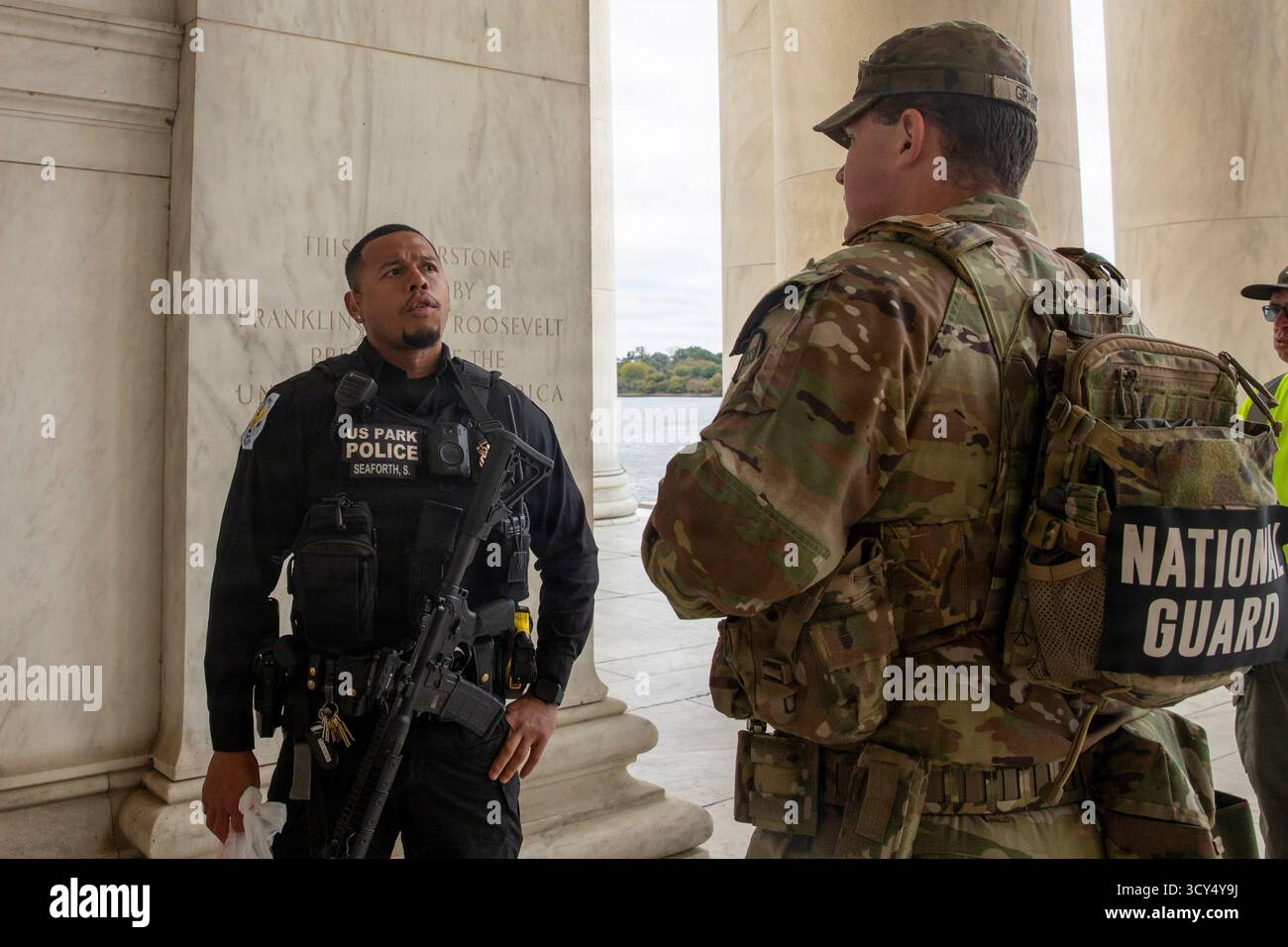 John Grant, avec le 4e bataillon du 118e régiment d'infanterie de la Garde nationale de Caroline du Sud, parle avec un officier de la police des parcs des États-Unis près du mémorial Thomas Jefferson lors d'une patrouille de présence à Washington, DC, le 13 octobre 2025. La mission Safe and Beautiful de D.C. renforce la collaboration entre la Garde nationale et les organismes d'application de la loi afin de protéger le public et de renforcer les liens communautaires. (Photo de la Garde nationale de l'armée américaine par le sergent Jalen Miller) Banque D'Images