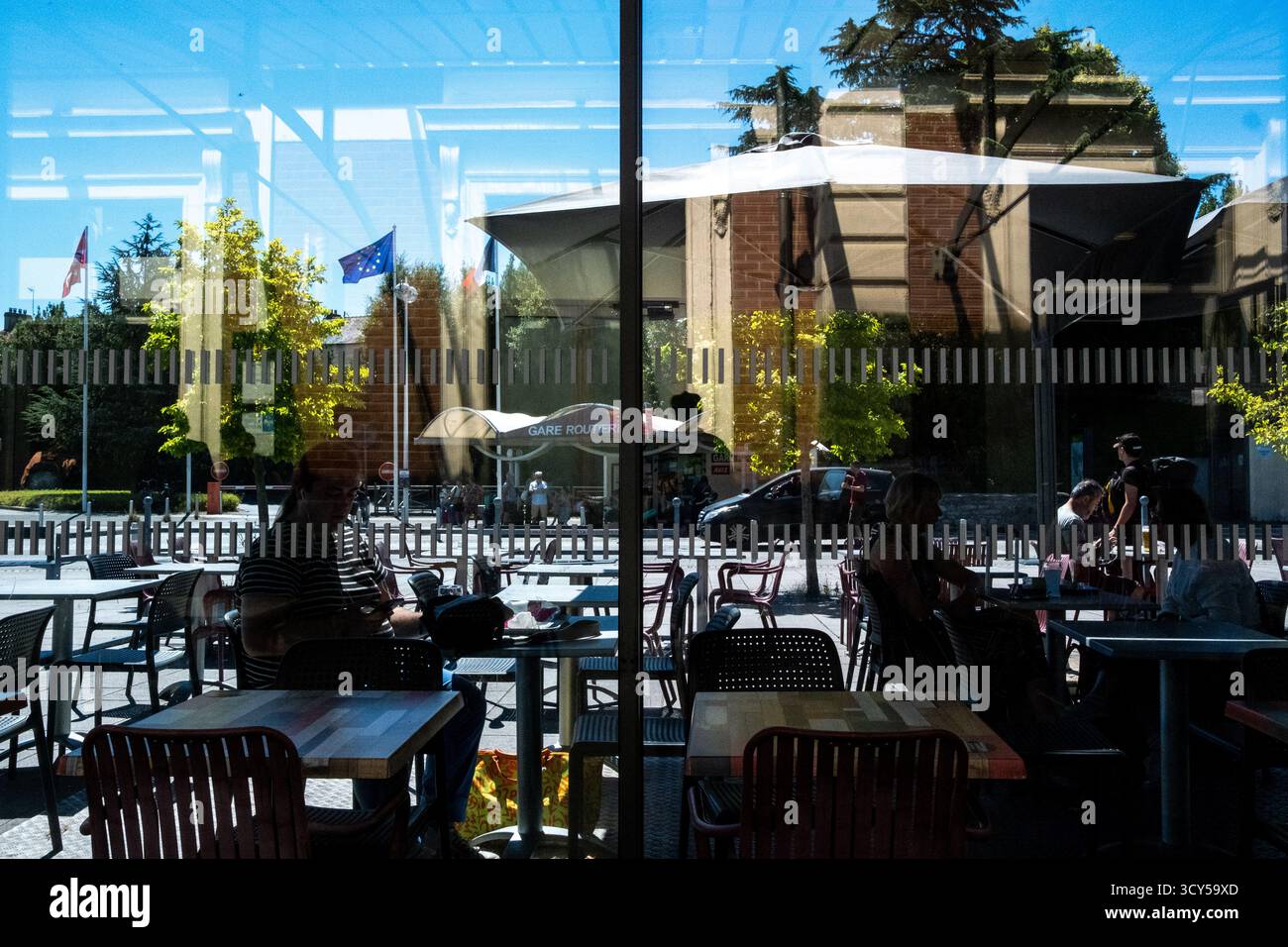 Vue des terrasses de cafés devant la gare de vannes dans le Morbihan en Bretagne en France le 24 juillet 2022. Les gens sont assis à des tables sous des parasols, Banque D'Images