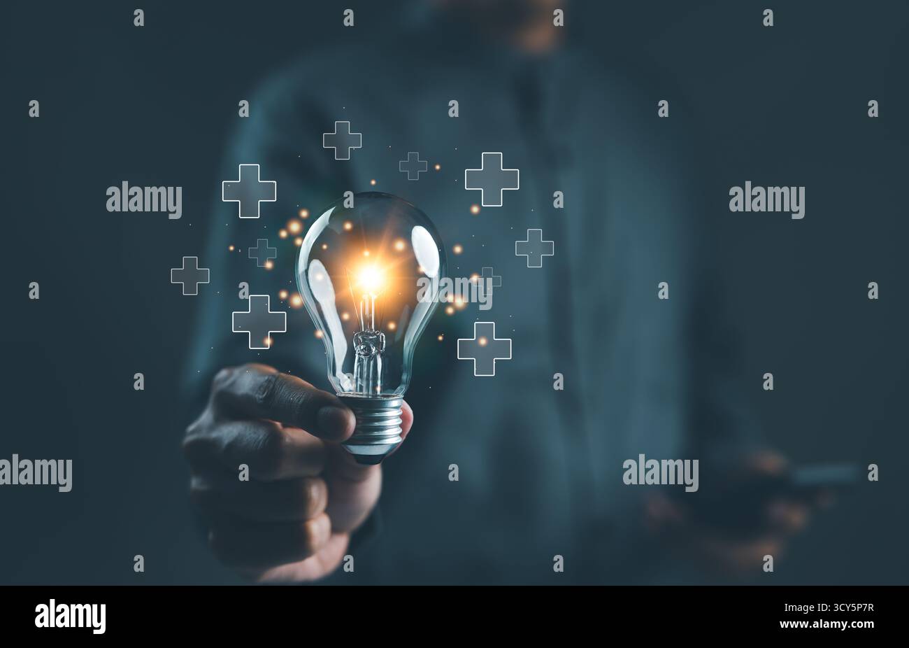 Concepts d'innovation et de génération d'idées. Personne tenant une ampoule avec des signes plus lumineux, symbolisant des idées créatives et une pensée innovante. intelligent Banque D'Images