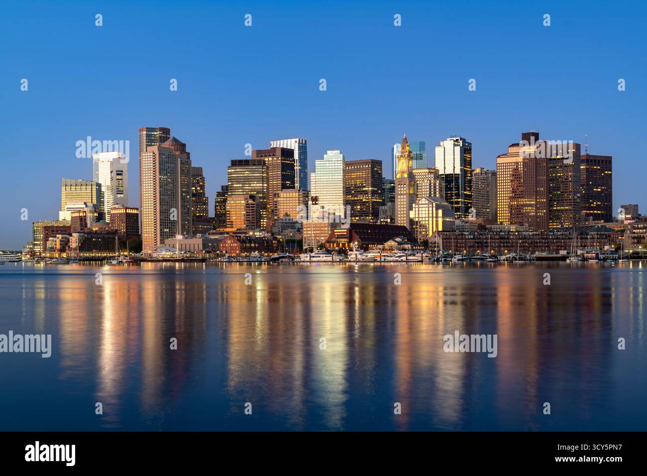Une vue imprenable au lever du soleil sur les gratte-ciel du centre-ville de Boston depuis East Boston, reflétée sur les eaux de l'Inner Harbor. Banque D'Images