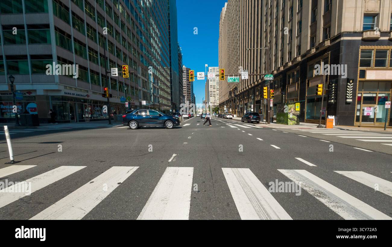 Une rue animée de la ville avec une voiture bleue conduisant sur la route. La rue est large et a beaucoup de trafic Banque D'Images Une rue animée de la ville avec une voiture bleue conduisant sur la route. La rue est large et a beaucoup de trafic Banque D'Images