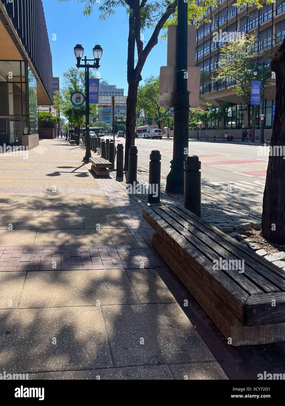 Un trottoir avec un banc et quelques poteaux. Le banc est vide Banque D'Images Un trottoir avec un banc et quelques poteaux. Le banc est vide Banque D'Images