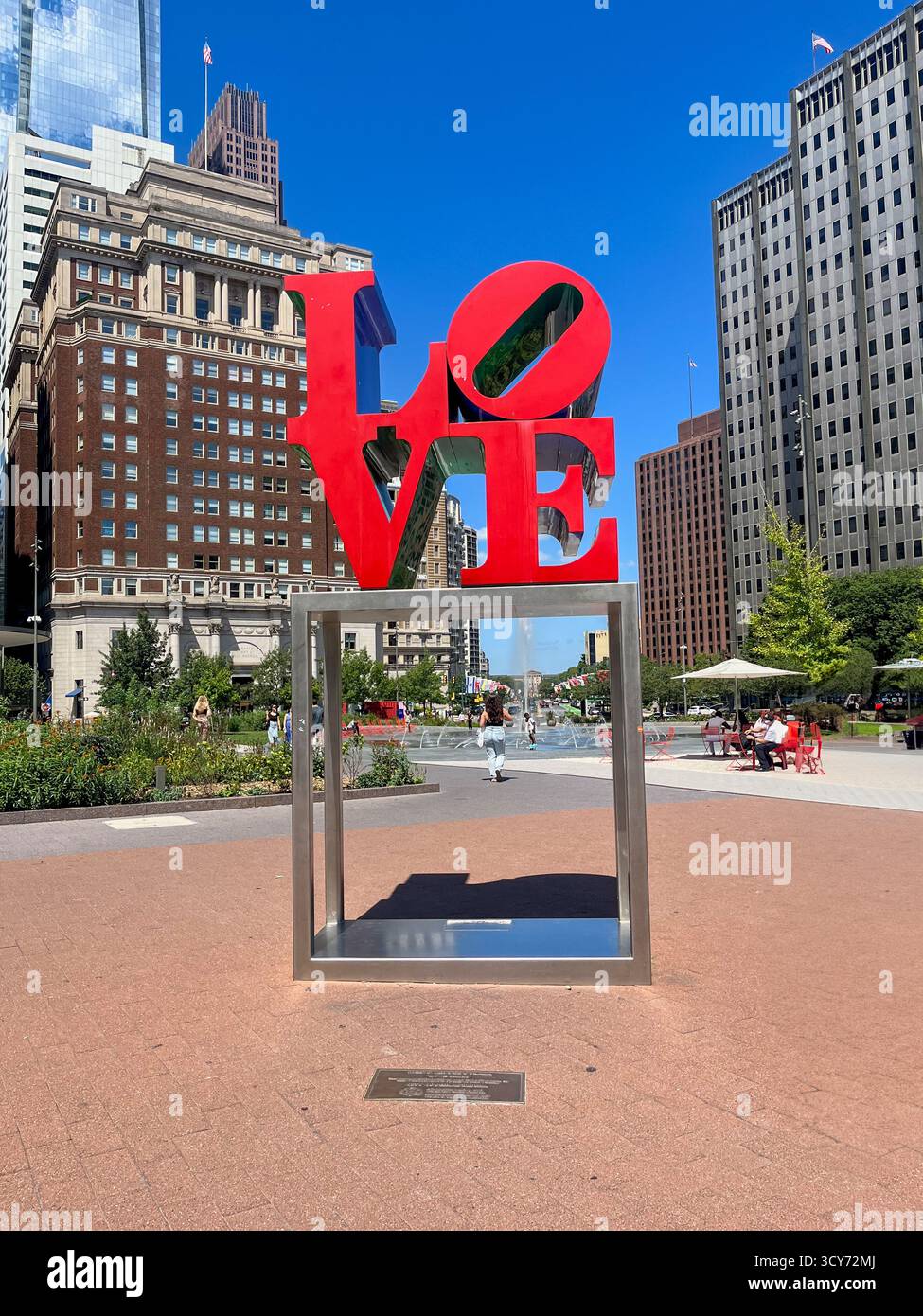 Une grande sculpture de coeur rouge dans un parc de la ville. Le cœur est entouré d'un cadre métallique et est placé sur une surface rouge. La scène est paisible et tonitruante Banque D'Images Une grande sculpture de coeur rouge dans un parc de la ville. Le cœur est entouré d'un cadre métallique et est placé sur une surface rouge. La scène est paisible et tonitruante Banque D'Images