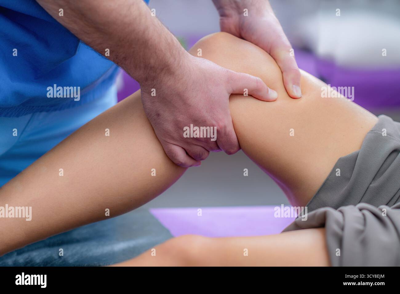 Femme recevant un massage du genou pendant une séance de physiothérapie pour soulager la tension musculaire, améliorer la circulation et réduire les douleurs articulaires. Banque D'Images