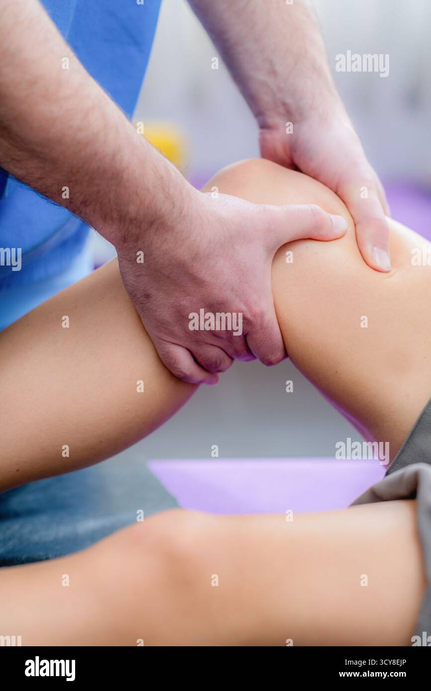 Femme recevant un massage du genou pendant une séance de physiothérapie pour soulager la tension musculaire, améliorer la circulation et réduire les douleurs articulaires. Banque D'Images