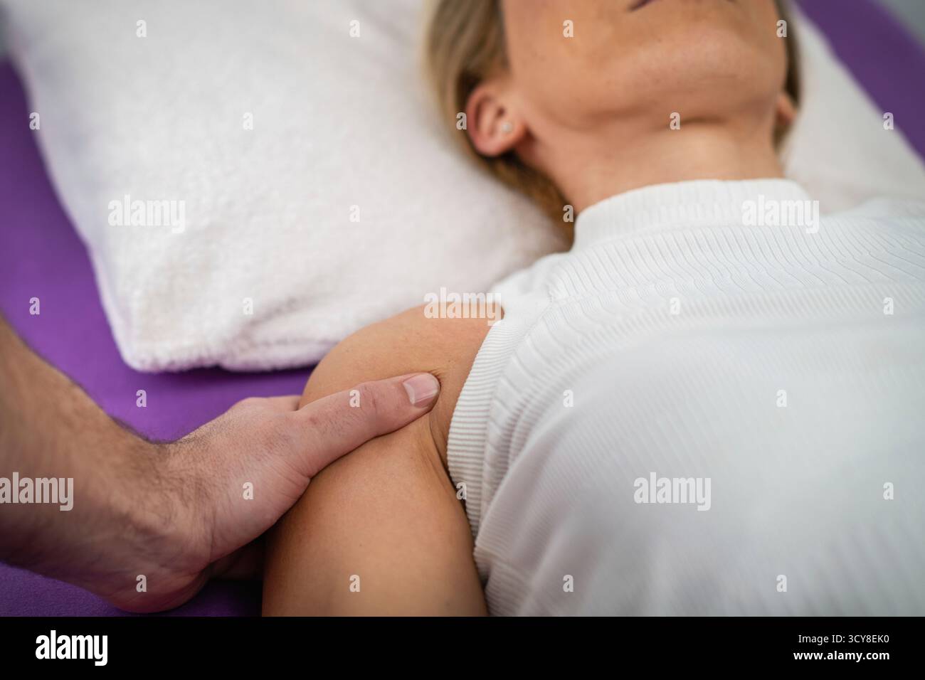 Femme recevant un massage des épaules pendant une séance de physiothérapie pour soulager la tension musculaire, améliorer la circulation et réduire les douleurs articulaires. Banque D'Images