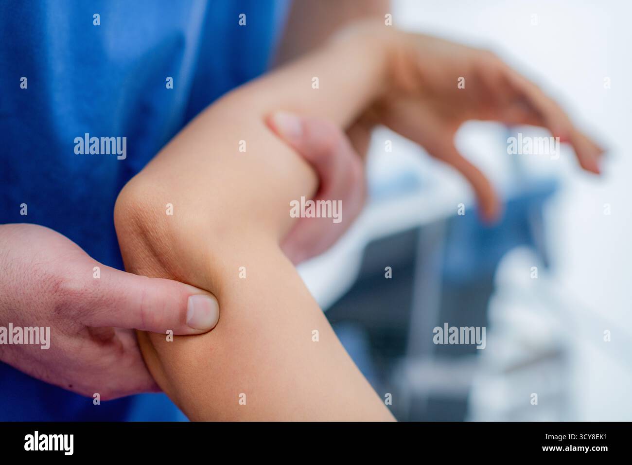 Femme recevant un massage du coude pendant une séance de physiothérapie pour soulager la tension musculaire, améliorer la circulation et réduire les douleurs articulaires. Banque D'Images