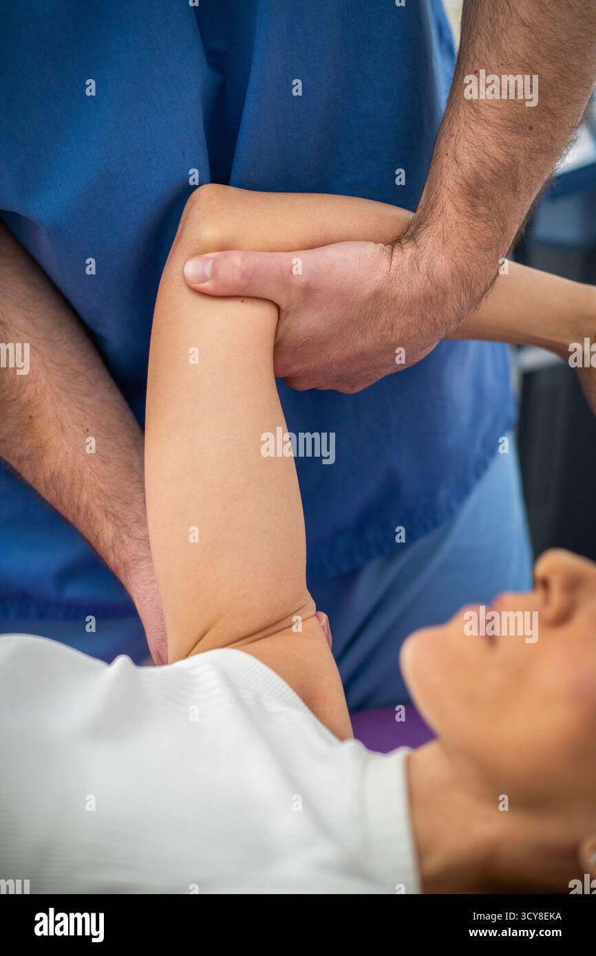 Femme recevant un massage des épaules pendant une séance de physiothérapie pour soulager la tension musculaire, améliorer la circulation et réduire les douleurs articulaires. Banque D'Images