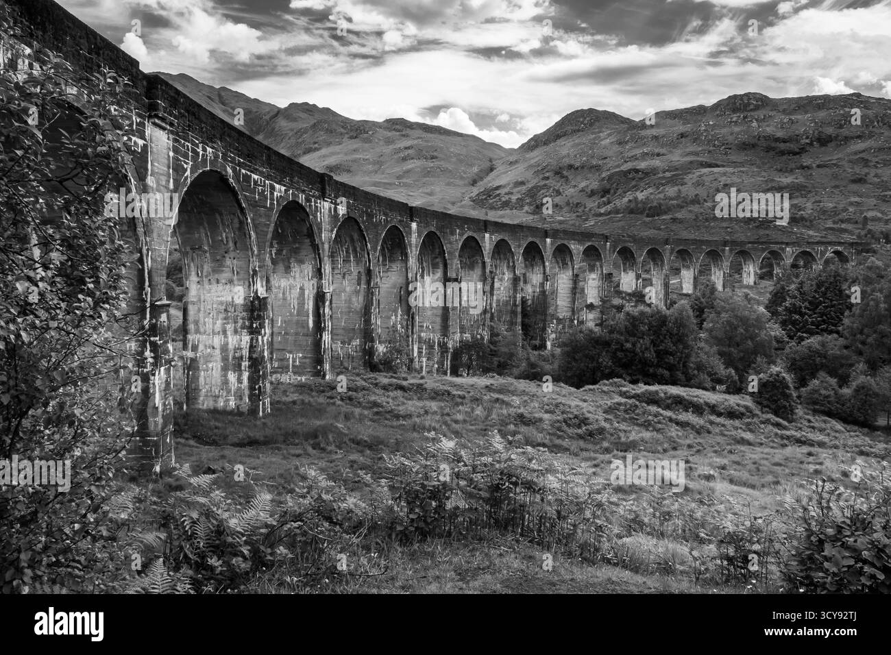 Vue monochrome du viaduc de Glenfinnan qui s'incurve à travers les Highlands écossais Banque D'Images