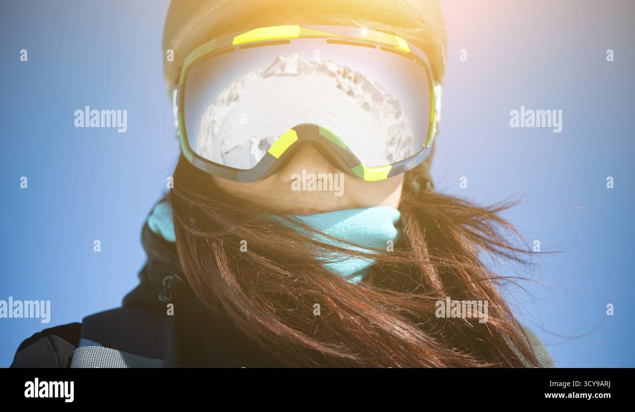 Brunette wearing helmet et verres fermer jusqu'à l'hiver bleu ciel Banque D'Images