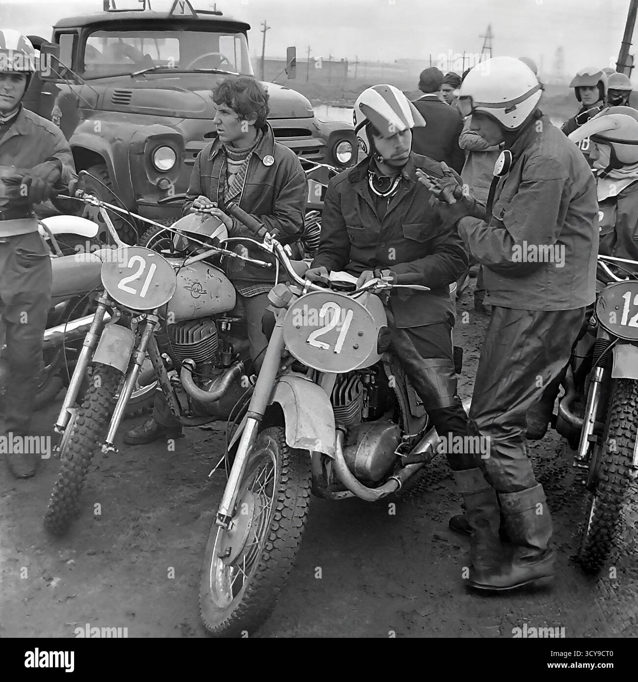 Une photo d'archives dynamique des années 1970 capture l'atmosphère gracieuse d'une course de motocross à Sloviansk, en RSS d'Ukraine. Les coureurs vêtus de casques vintage et d'équipements de protection chevauchent leurs puissantes motos de l'ère soviétique (probablement des modèles CZ ou Izh) sur une piste boueuse de terre, prêts pour la compétition. Les spectateurs se rassemblent à proximité, ajoutant à l'excitation de l'événement de sport automobile local. Cette image dépeint de manière éclatante la passion pour le sport et les rassemblements communautaires dans un Donbass pacifique avant la guerre Banque D'Images