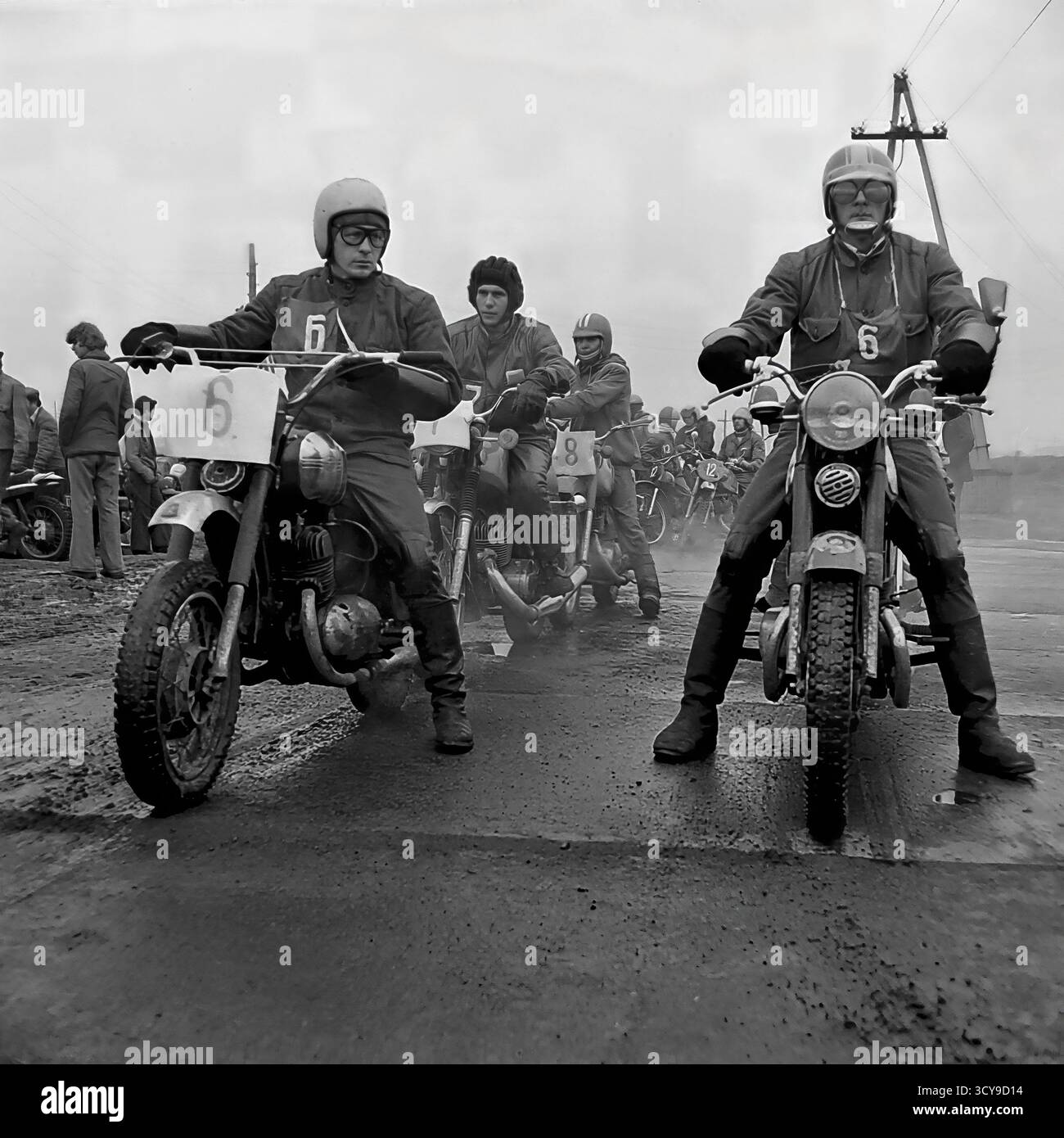 Une photo d'archives dynamique des années 1970 capture l'atmosphère gracieuse d'une course de motocross à Sloviansk, en RSS d'Ukraine. Les coureurs vêtus de casques vintage et d'équipements de protection chevauchent leurs puissantes motos de l'ère soviétique (probablement des modèles CZ ou Izh) sur une piste boueuse de terre, prêts pour la compétition. Les spectateurs se rassemblent à proximité, ajoutant à l'excitation de l'événement de sport automobile local. Cette image dépeint de manière éclatante la passion pour le sport et les rassemblements communautaires dans un Donbass pacifique avant la guerre Banque D'Images