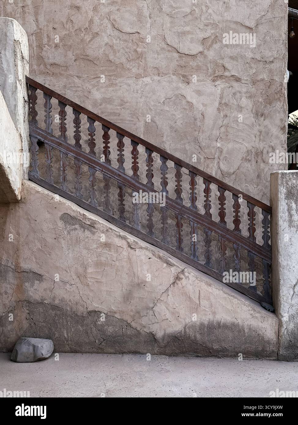 Passage étroit Moody avec escalier ombragé et mur texturé à Al Seef, idéal pour le voyage, l'éditorial et la narration du patrimoine. Banque D'Images