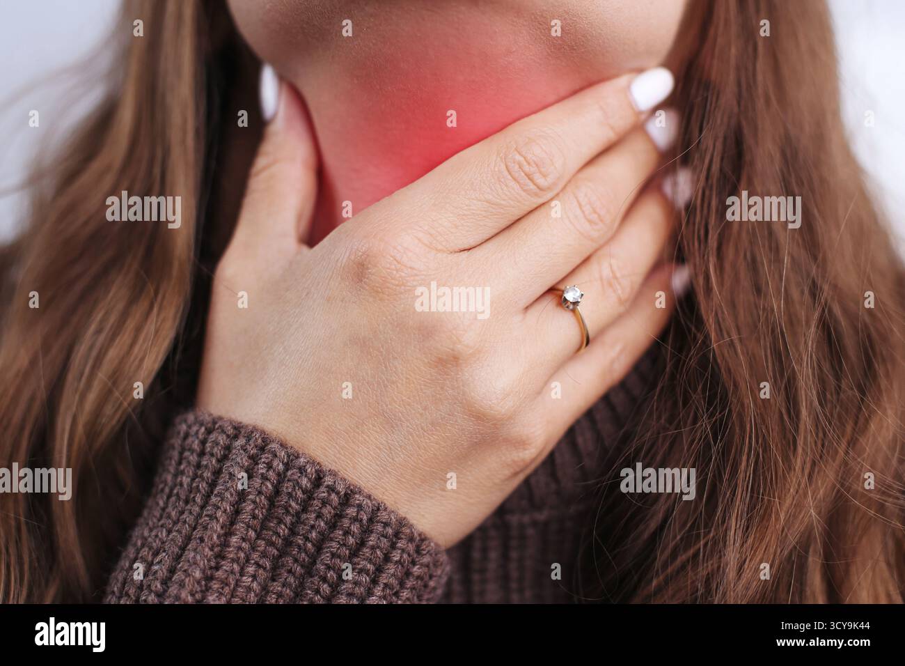 Femme touchant le mal de gorge avec la peau rouge enflammée. Concept de maladie, douleur et symptômes du rhume. Soins de santé et traitement des infections à domicile. Banque D'Images