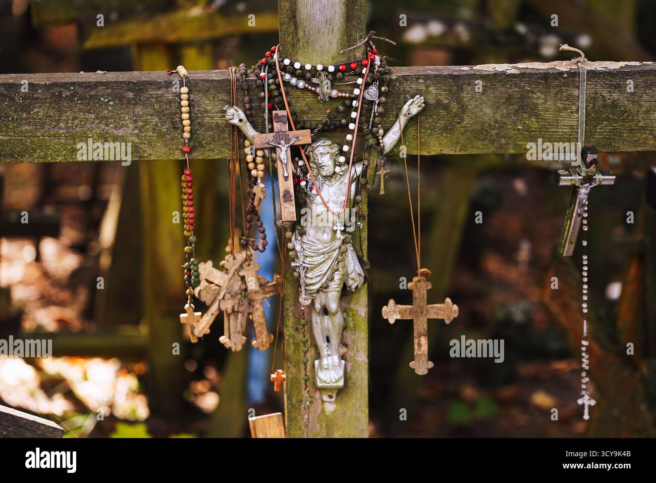 Croix religieuses et chapelets suspendus à une croix en bois. Symbole de foi et de spiritualité. Lieu de pèlerinage chrétien avec des signes de dévotion et de prière. Banque D'Images