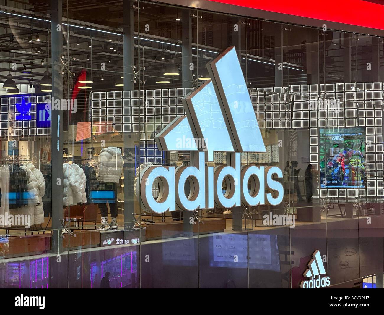 Chongqing, Chine - 5 décembre 2023 : enseigne de la vitrine Adidas. Adidas AG est une société allemande de vêtements et chaussures de sport. Banque D'Images