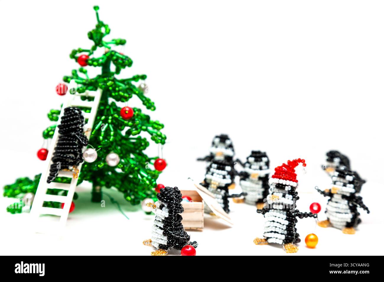 Jouets de petits pingouins près de l'arbre du nouvel an, brodés de perles Banque D'Images