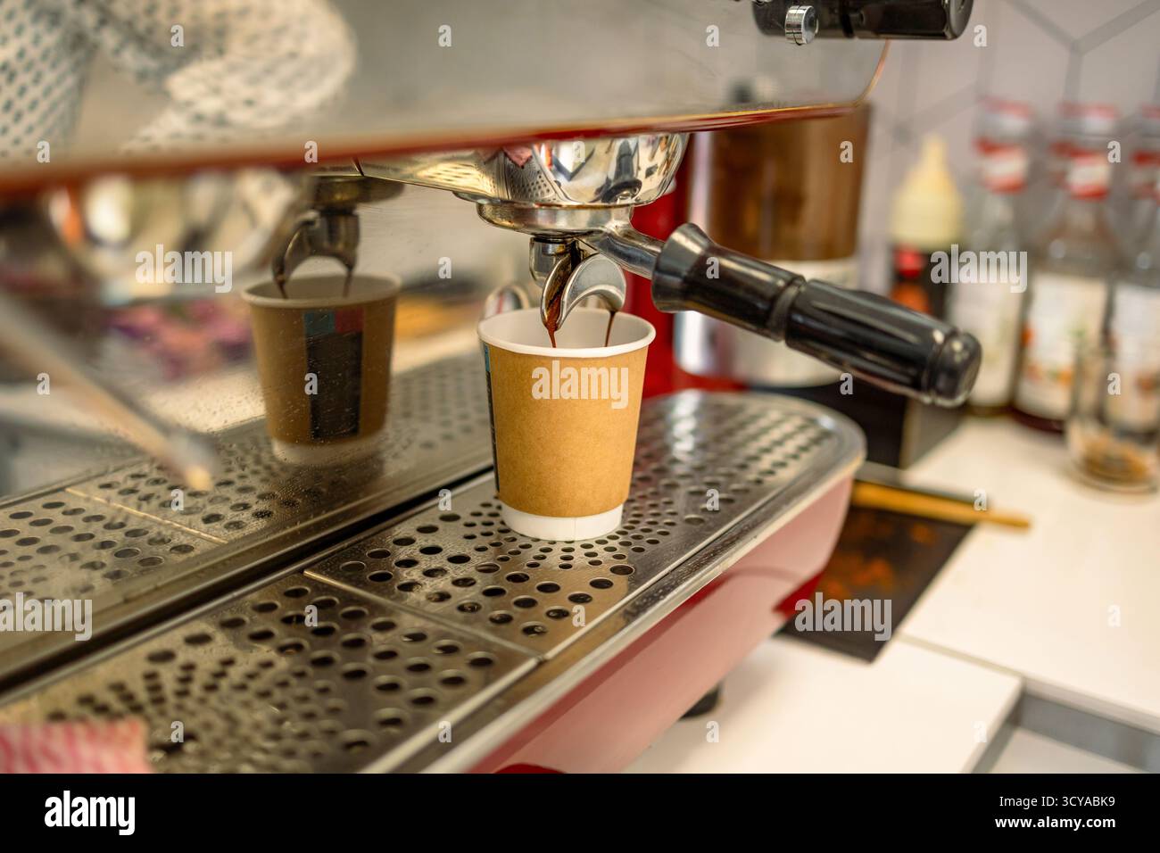 Machine à café versant le café dans une tasse de papier, gros plan Banque D'Images