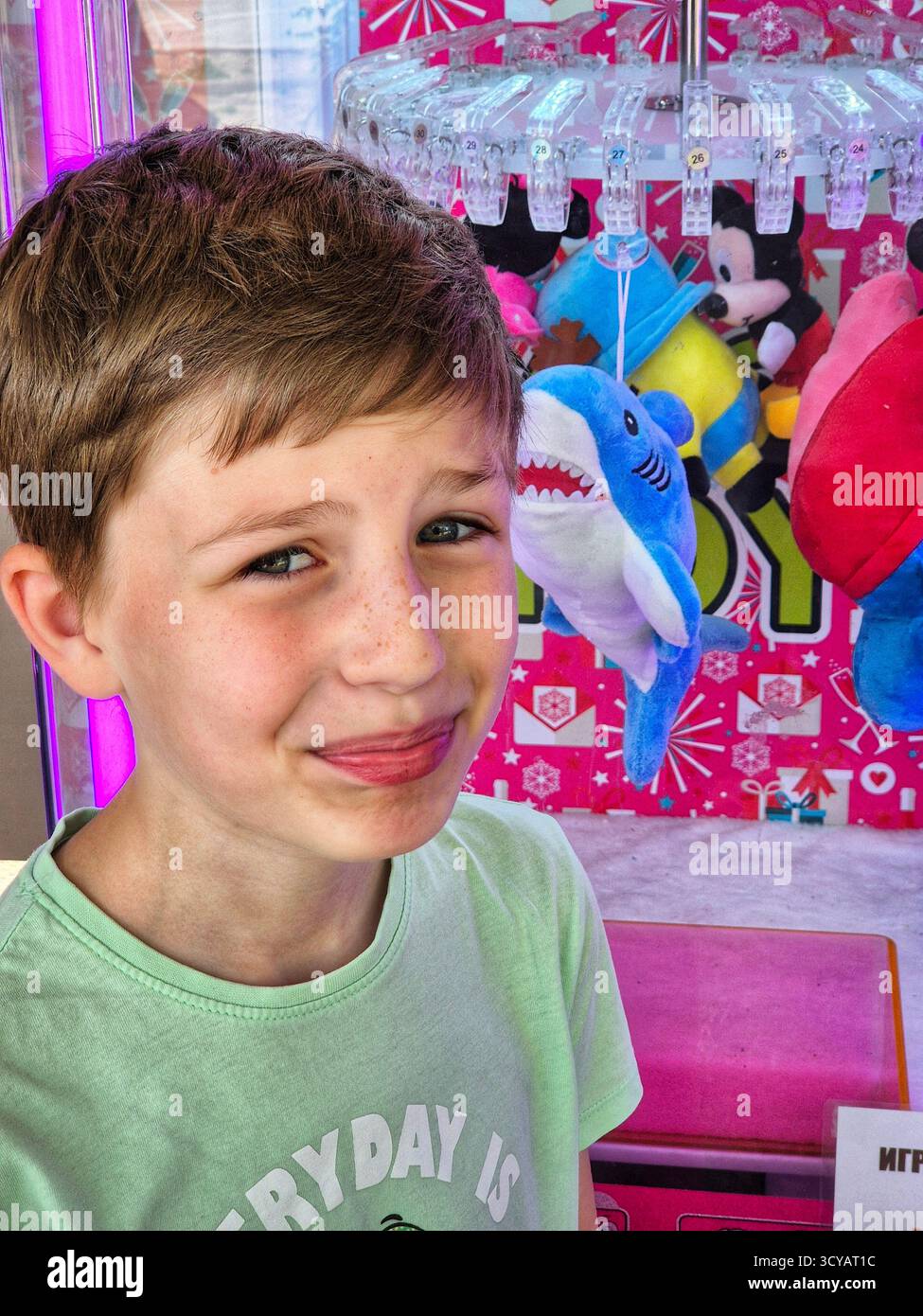 L'expression faciale d'un garçon reflétant la frustration ou la réflexion, sur un fond de jeu lumineux Banque D'Images