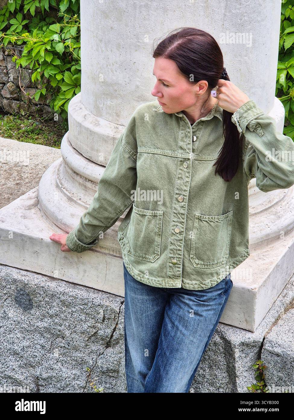 Une femme pose sur la toile de fond d'une colonne massive, soulignant l'atmosphère d'une ville ancienne - Image de stock capturée avec un smartphone