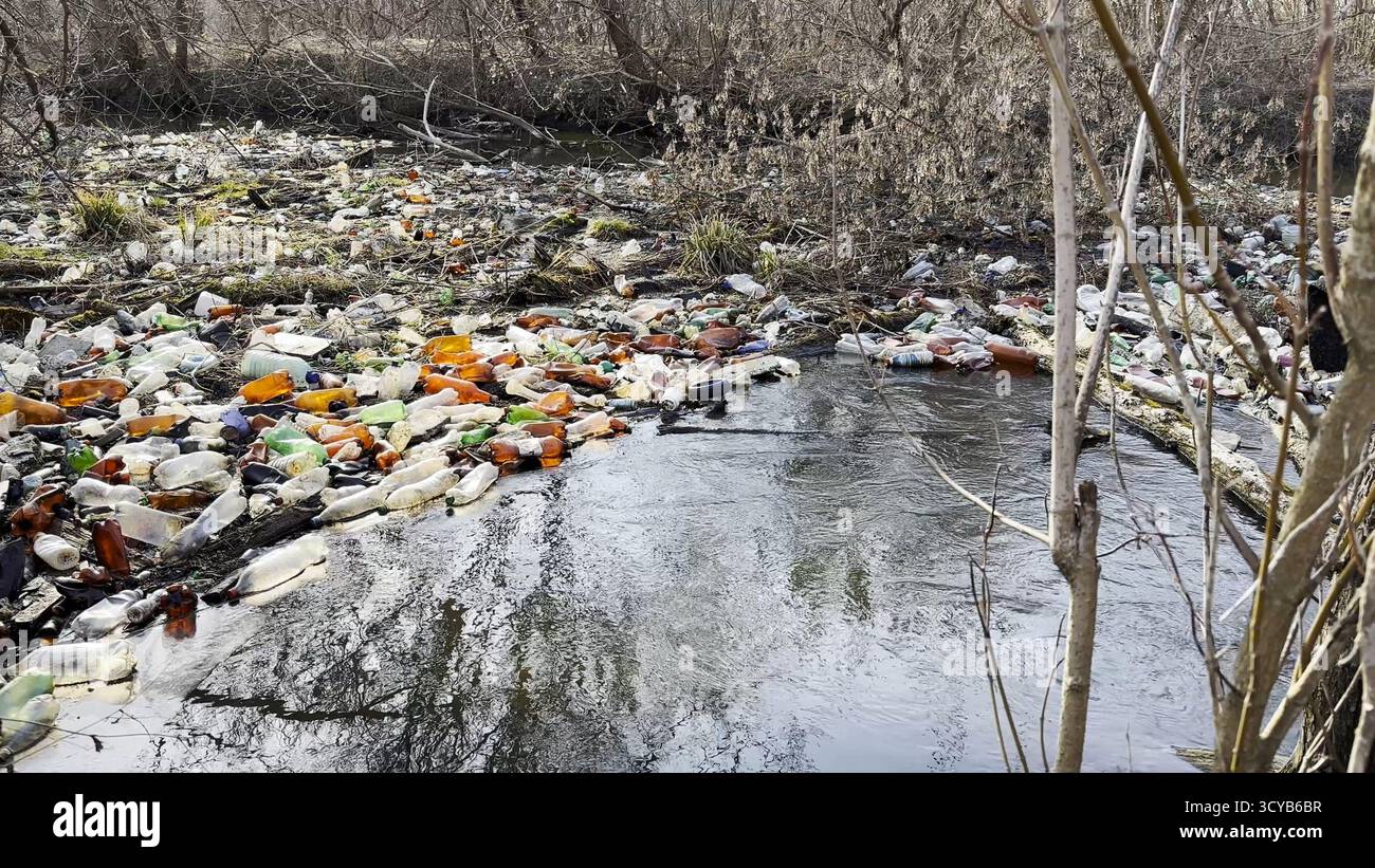 La rivière sale est polluée par de nombreuses bouteilles en plastique. Beaucoup de déchets sont jetés dans des endroits ouverts et librement disponibles dans la nature. Environnement mondial Banque D'Images