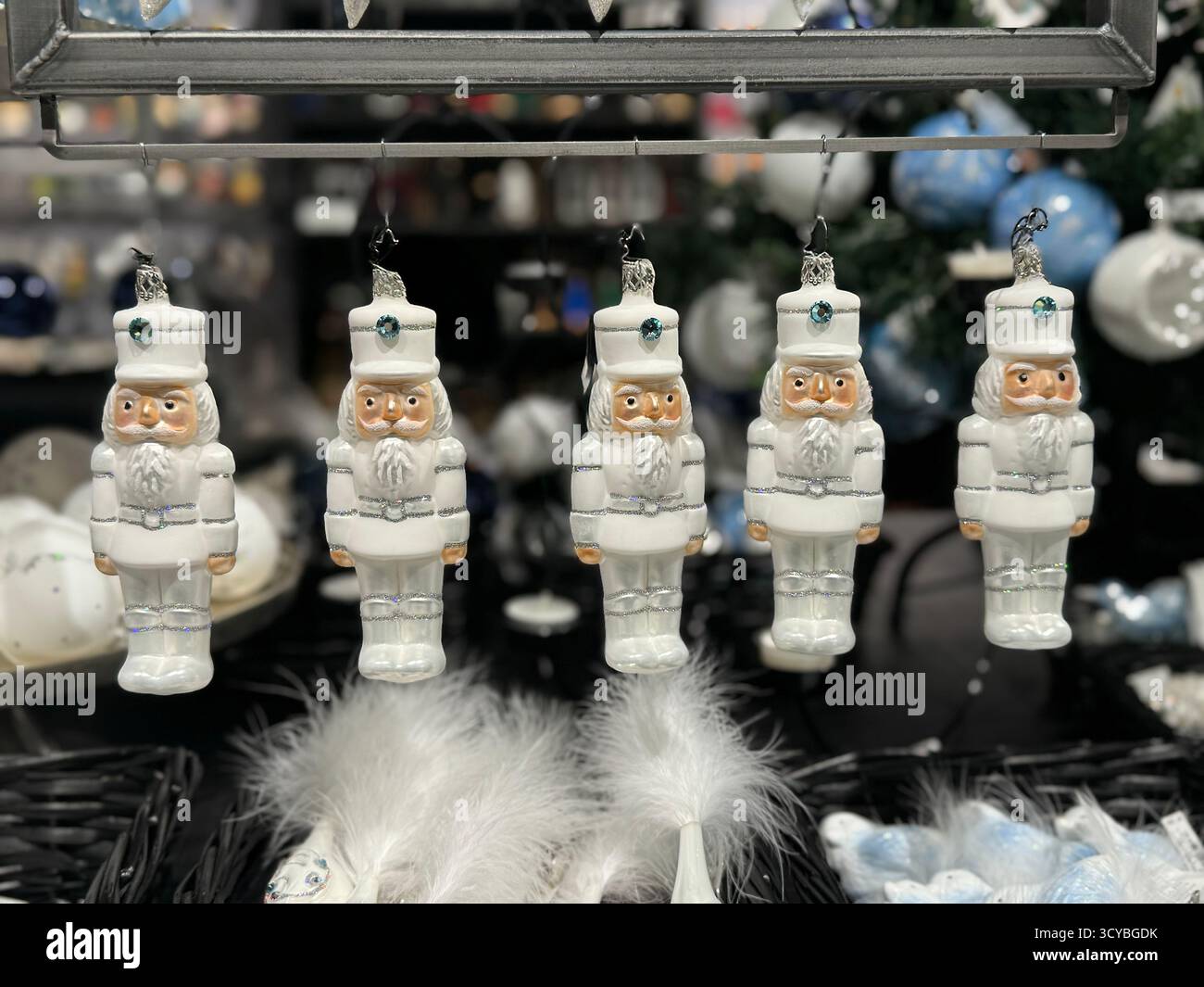 Rangée d'ornements d'arbre de Noël casse-noix en verre blanc suspendus dans un magasin - Image de stock capturée avec un smartphone
