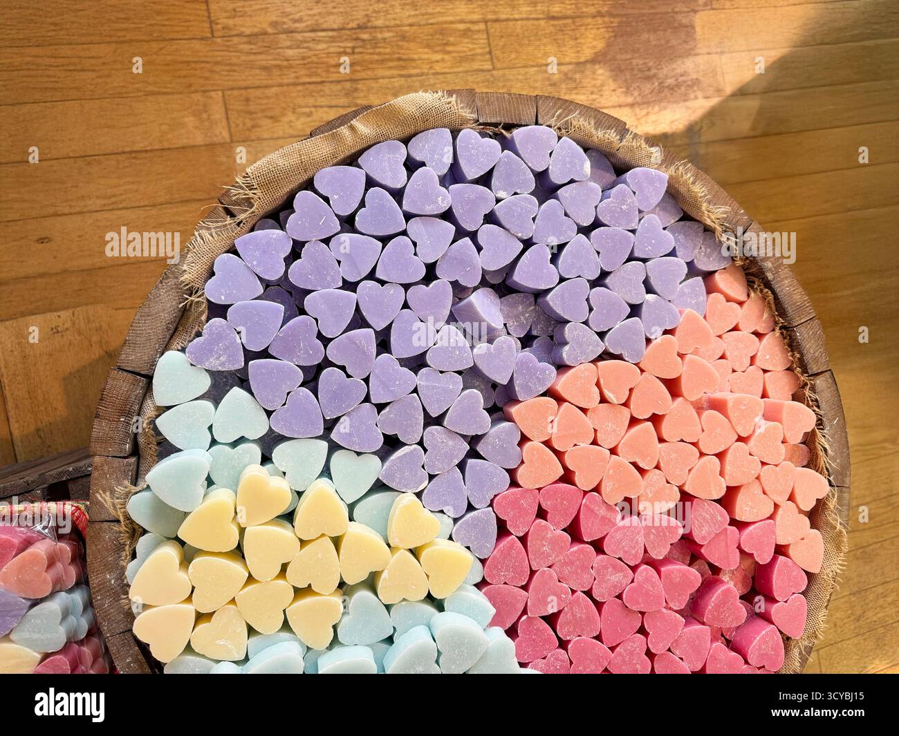 Vue aérienne de savons colorés en forme de coeur dans un tonneau en bois Banque D'Images