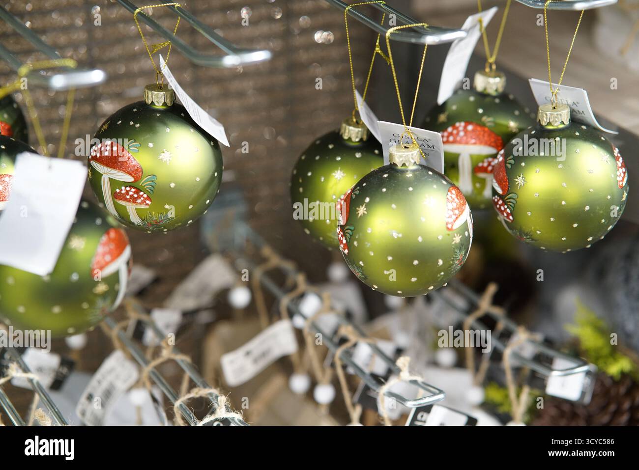 Boules de Noël vertes ornées d'un tabouret rouge accrochées à l'étalage festif du Haskins Garden Centre.Haskins Garden Centre, Snowhill, Copthorne Banque D'Images