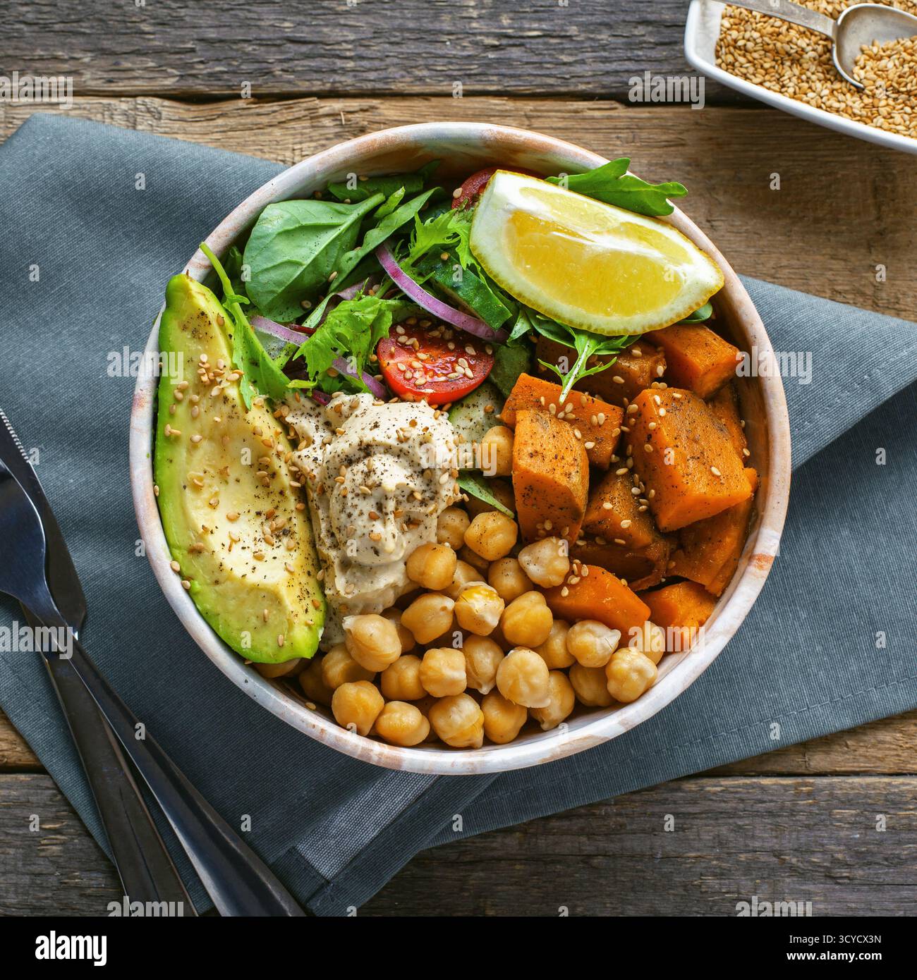 Bol de pois chiches, salade, patate douce, salade et avocat. Photographie vue de dessus. Banque D'Images