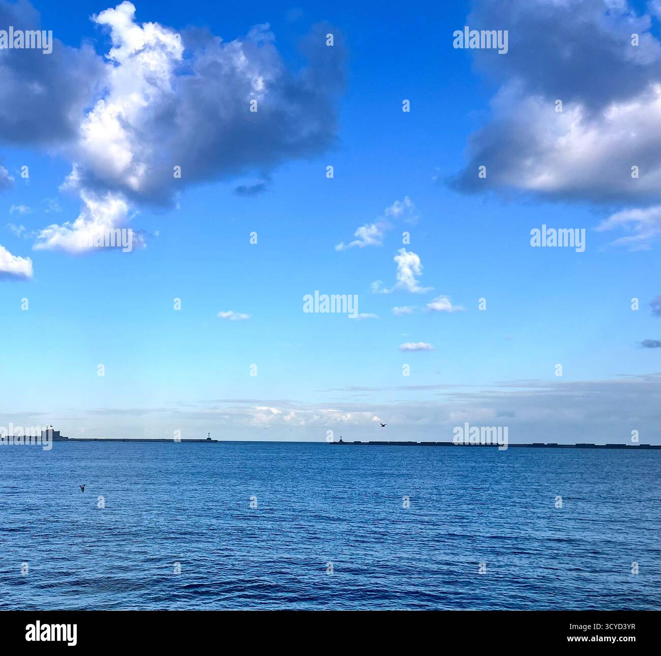 Paysage marin paisible avec une eau bleue calme, des nuages doux et un horizon ouvert, idéal pour les voyages, la détente, et les concepts de liberté. - Image de stock capturée avec un smartphone