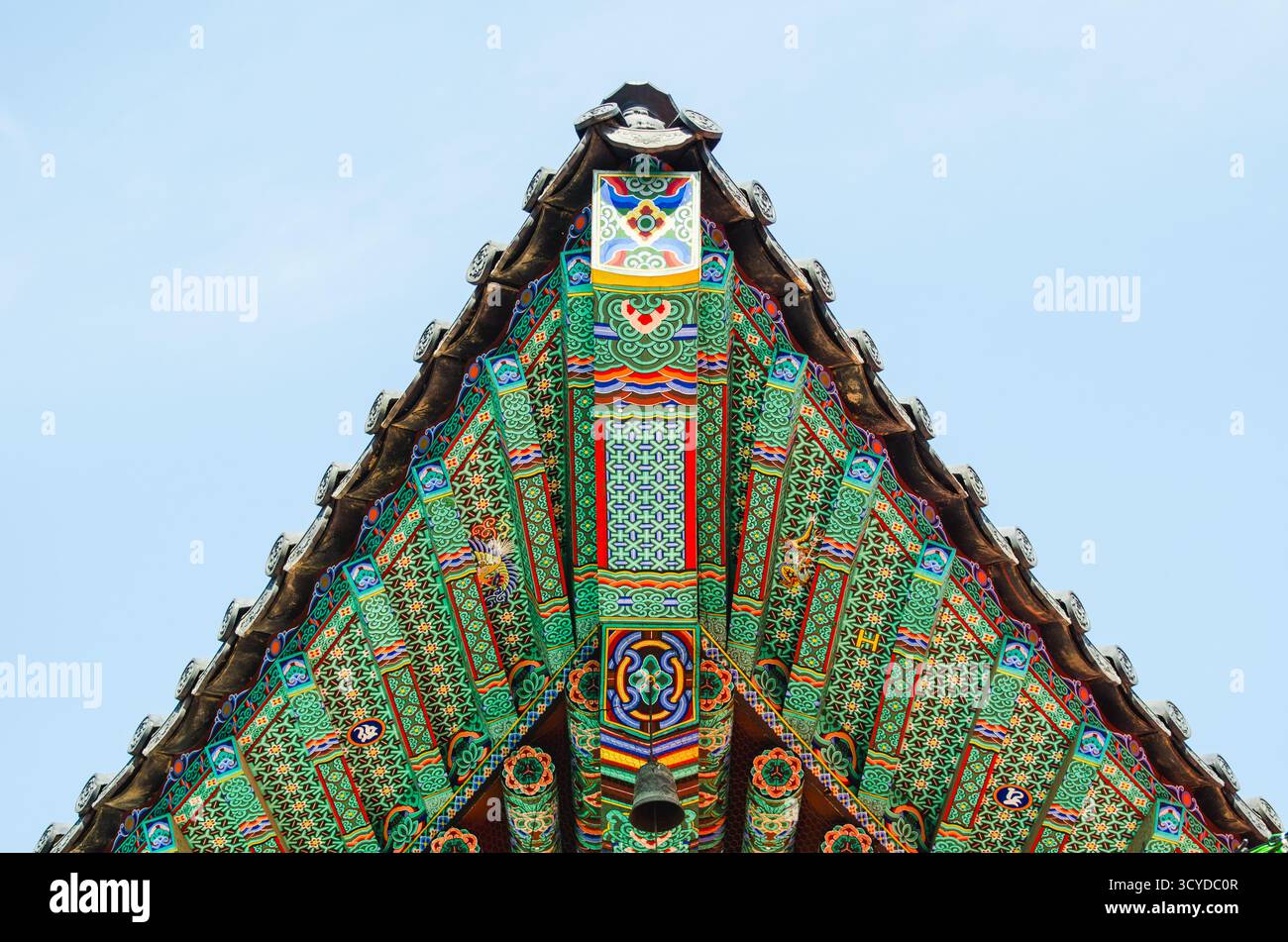 Toit de temple coréen orné avec des motifs sur le ciel bleu clair Banque D'Images