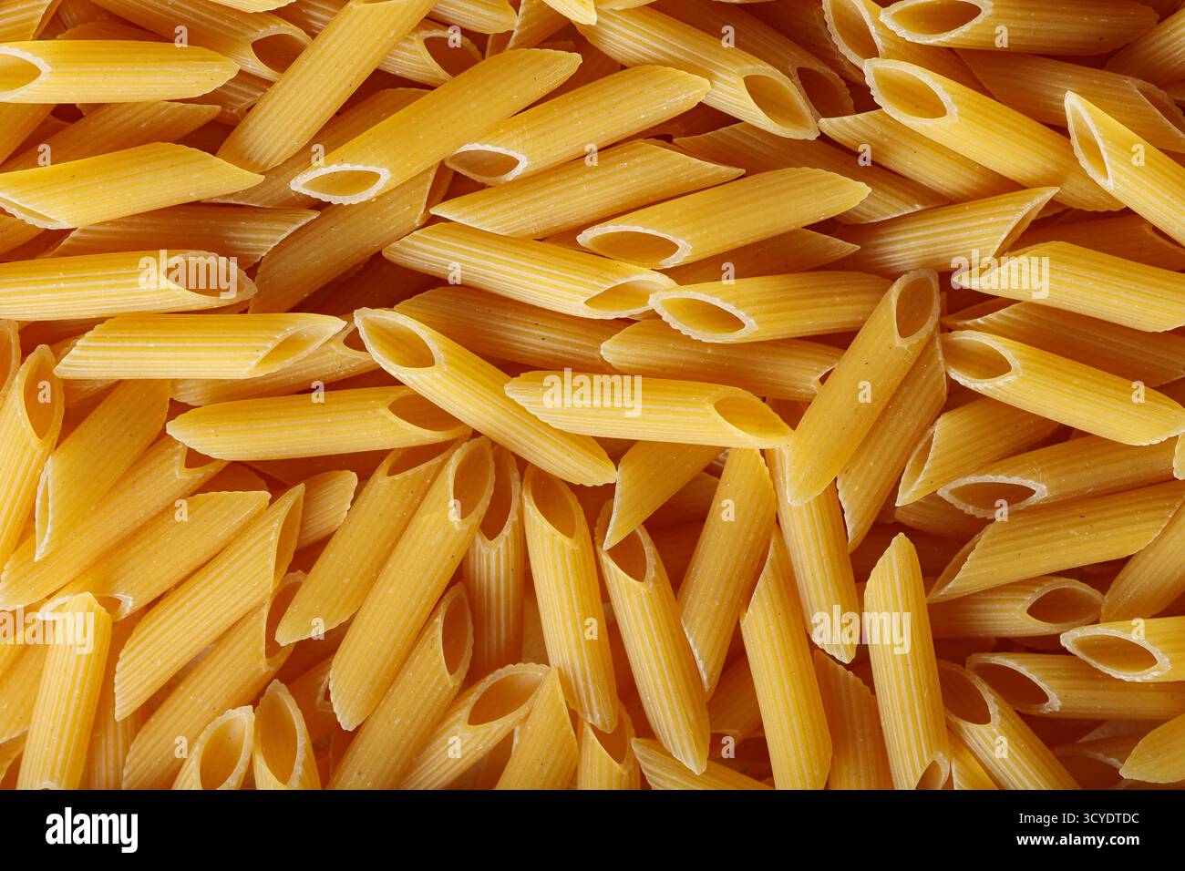 Pâtes Penne brutes en forme de tube avec texture organique vue de dessus Banque D'Images