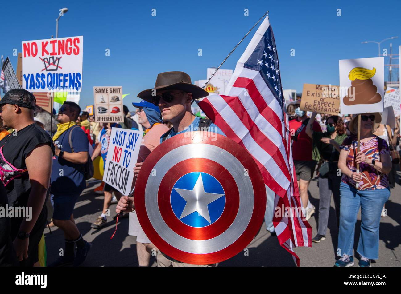 San Diego, Californie, États-Unis. 18 octobre 2025. Un manifestant portant un drapeau américain et un bouclier de Captain America marche avec d'autres porteurs de pancartes indiquant « pas de rois » et « dites simplement non au fascisme » pendant la manifestation « pas de rois ». (Crédit image : © Alvaro Diaz/ZUMA Press Wire) USAGE ÉDITORIAL SEULEMENT ! Non destiné à UN USAGE commercial ! Banque D'Images