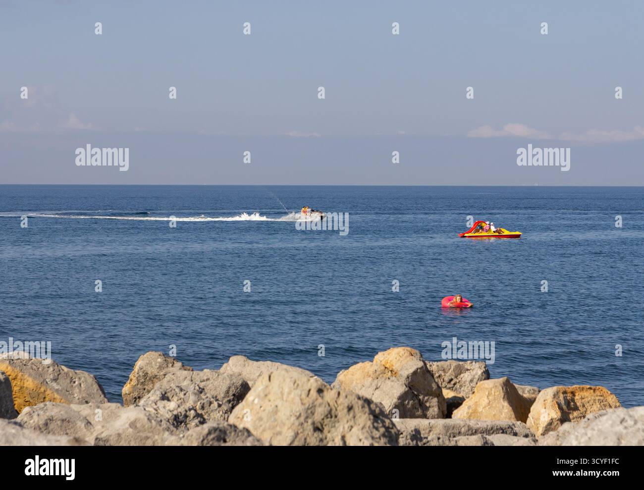 Un bateau et des jet skis flottent sur la mer. Banque D'Images