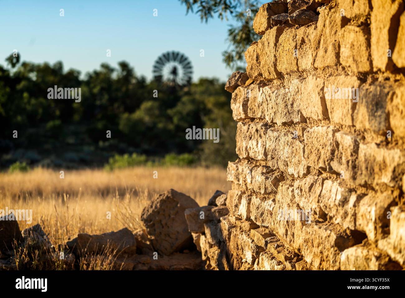 Vieux mur de grès et moulin à vent, Old Cork Station, Winton, Queensland occidental, Australie Banque D'Images
