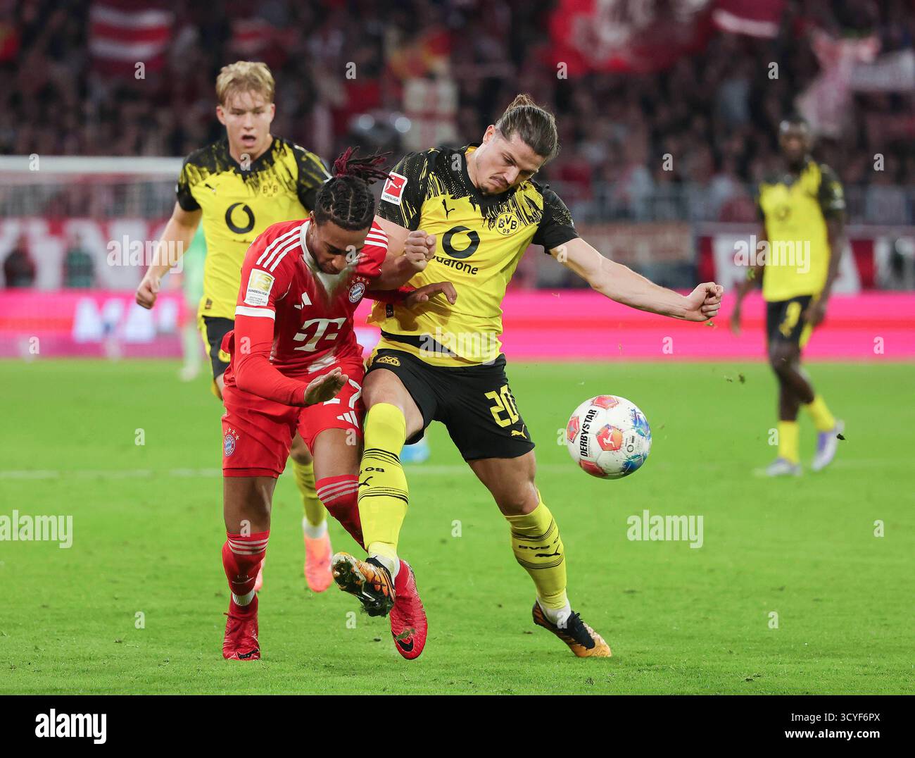 Munich, Allemagne. 18 octobre 2025. Michael Olise (G, avant) du Bayern Munich affronte Marcel Sabitzer du Borussia Dortmund lors du match de football de première division allemande de Bundesliga entre le Bayern Munich et le Borussia Dortmund à Munich, Allemagne, le 18 octobre 2025. Crédit : Philippe Ruiz/Xinhua/Alamy Live News Banque D'Images