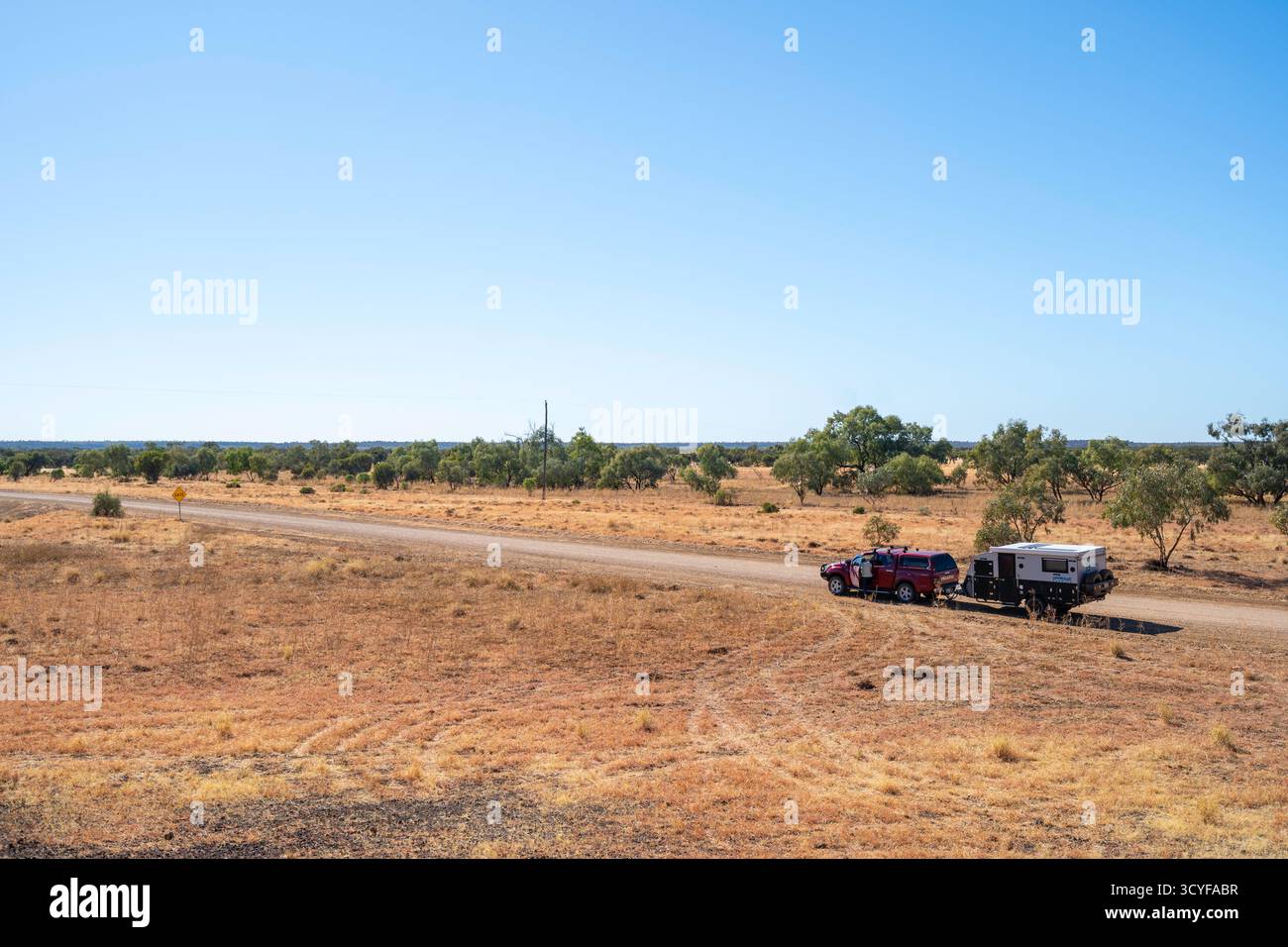 Voiture et caravane sur une route de campagne déserte, région de Winton, Queensland occidental, Australie Banque D'Images