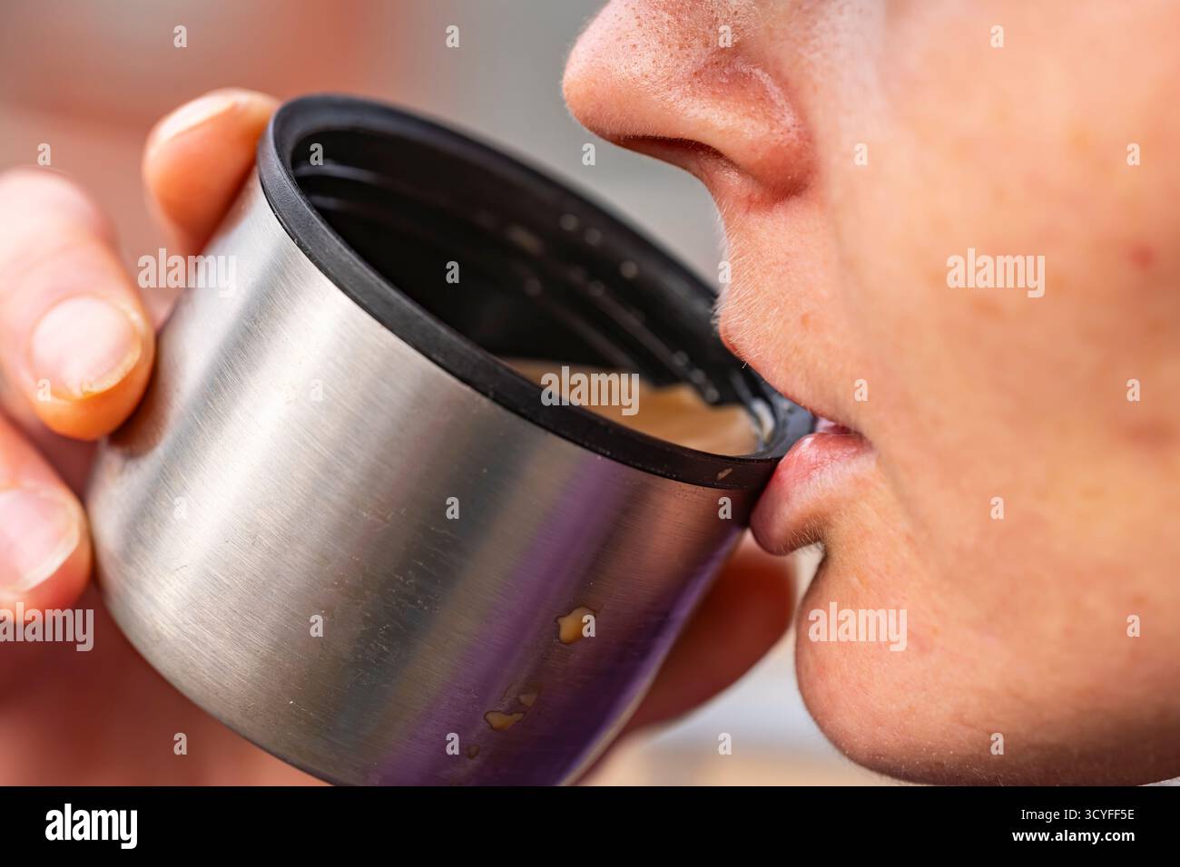 La moitié du visage de la fille appréciant le café chaud de Thermos Mug — vue de côté photo extérieure Banque D'Images