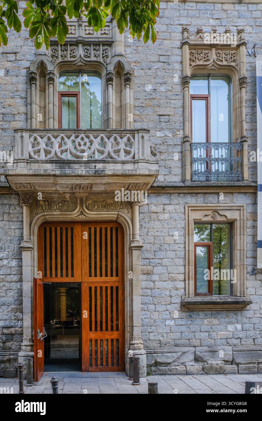 Façade historique en pierre avec grande porte d'entrée en bois et balcon en pierre orné, avec détails architecturaux néogothiques Banque D'Images