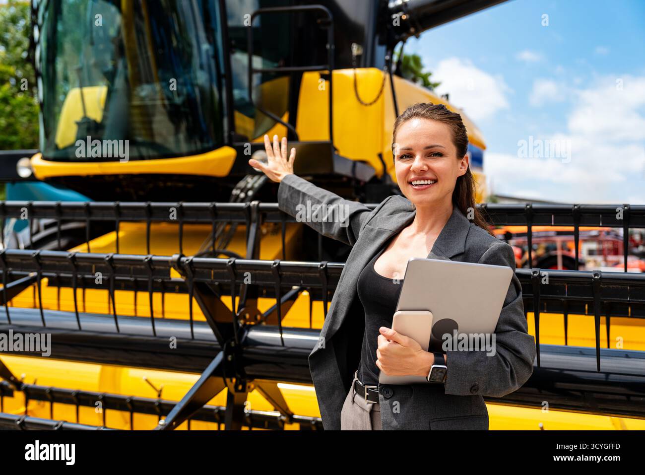 Professionnelle de l'agroalimentaire présentant la moissonneuse-batteuse à un concessionnaire d'équipement agricole Banque D'Images