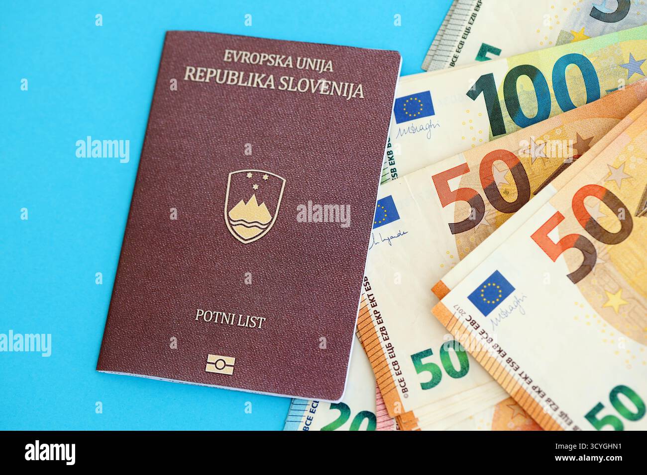 Le passeport slovène se trouve avec des billets de banque en euros sur fond bleu gros plan. Salaire et retraite en Europe concept Banque D'Images