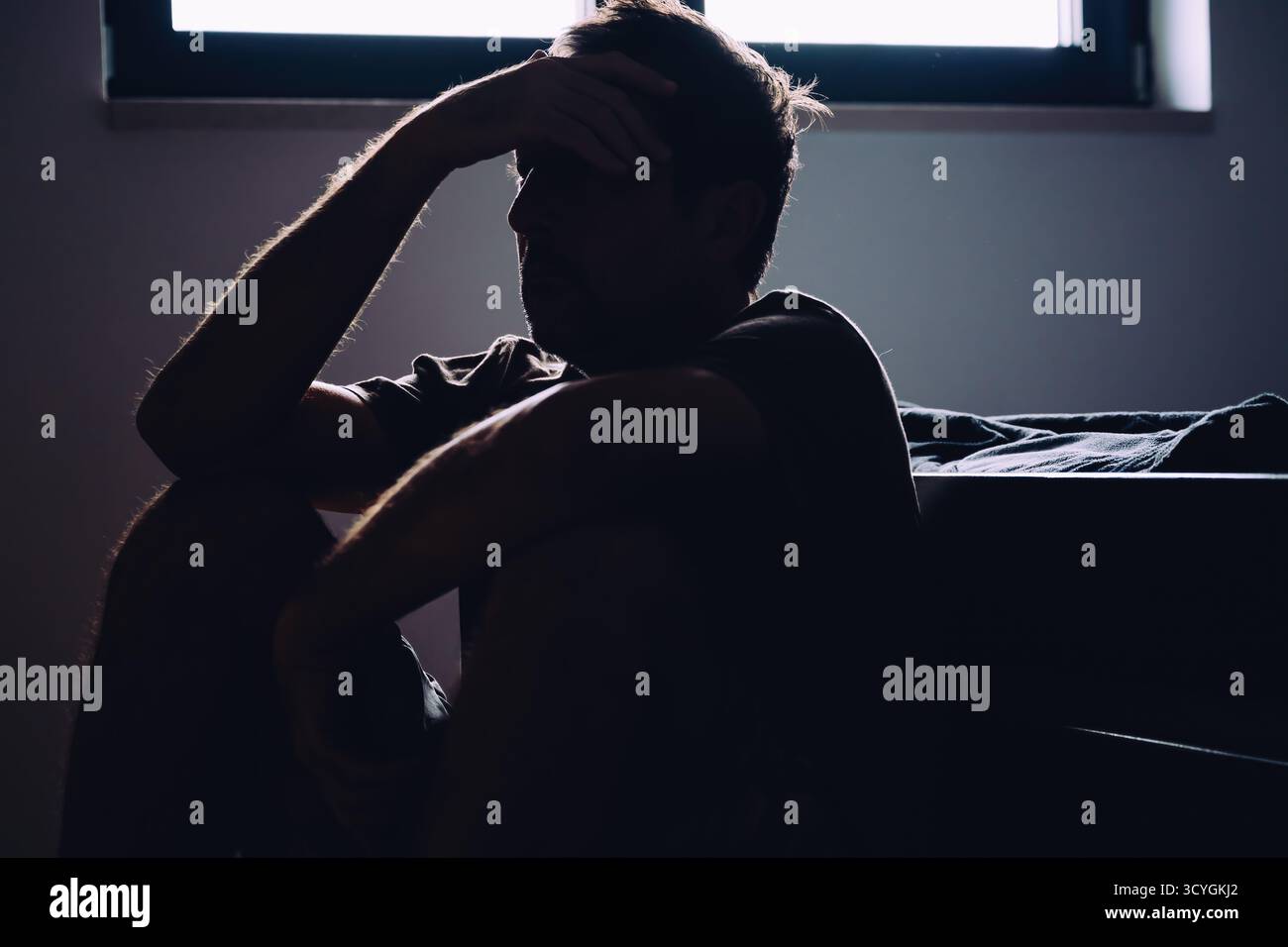 Silhouette homme mature assis sans espoir et déprimé sur le sol de la chambre, santé mentale et concept de solitude. Mise au point sélective. Banque D'Images