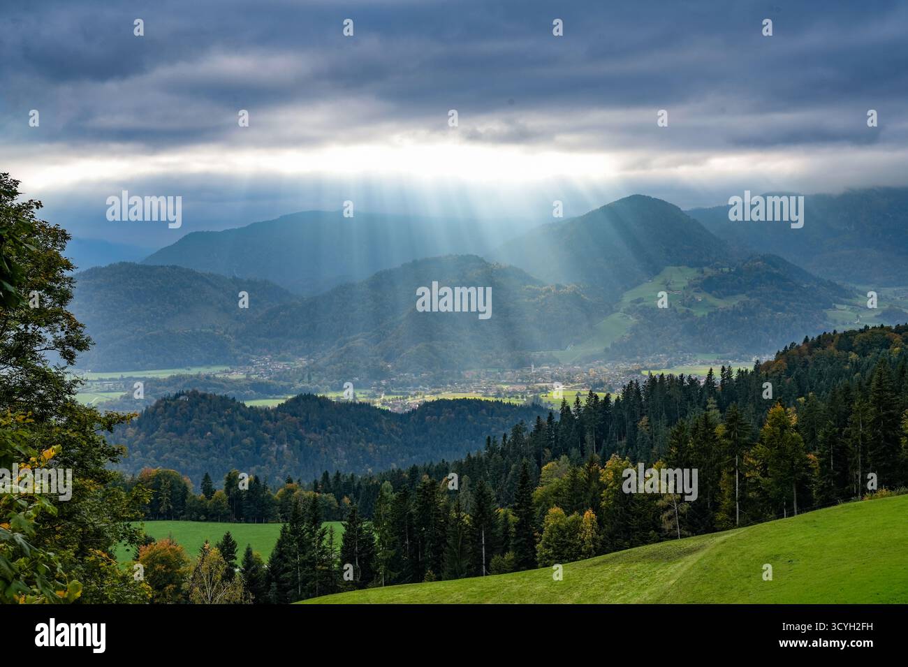 Paysage de montagne dans les Préalpes bavaroises dans la vallée inférieure de l'Inn avec des rayons de soleil brisant à travers les nuages. Vue d'Oberaudorf, Une municipalité Banque D'Images